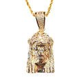 A gold Jesus head pendant necklace paved with small diamonds, hanging from a gold chain against a plain white background.