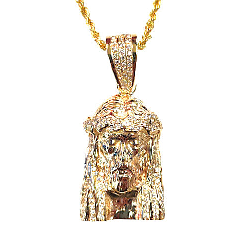 A gold Jesus head pendant necklace paved with small diamonds, hanging from a gold chain against a plain white background.