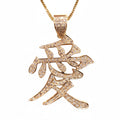 A gold pendant necklace featuring a stylized Chinese calligraphy character for 'Love' (爱), embellished with small clear pavé stones, suspended from a gold chain against a plain white background.