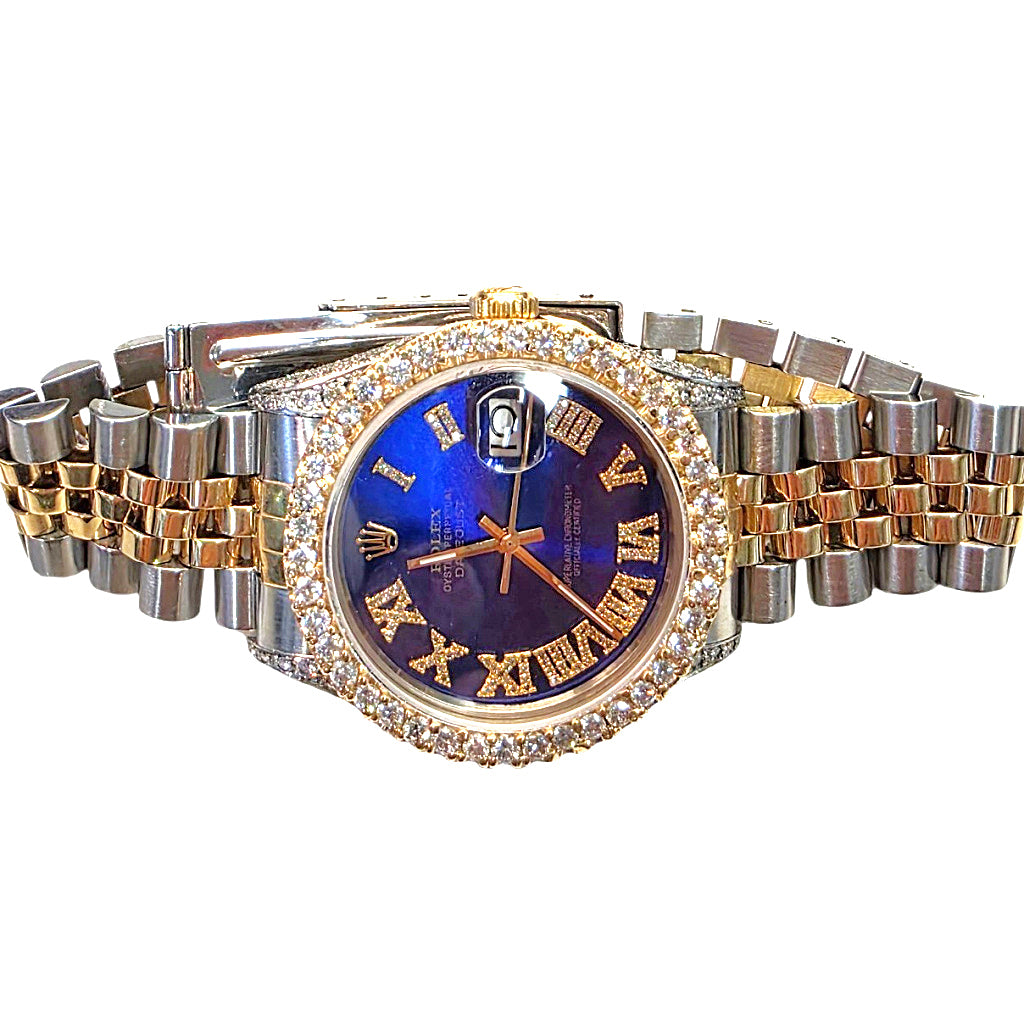 A two-tone Rolex Datejust watch with a blue sunburst dial, gold-tone Roman numerals, a diamond-encrusted bezel, and a matching two-tone link bracelet on a white background.