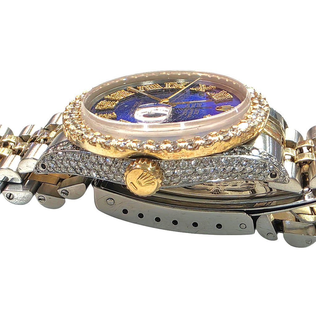 A luxury two-tone wristwatch with a gold and silver-tone metal bracelet, featuring a blue dial, a gold-tone bezel, and diamond pavé accents on the case and bracelet.
