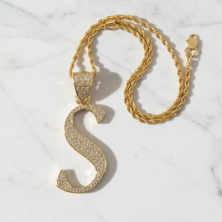 S pendant on white marble